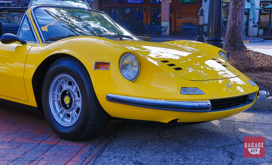 Front view of a Ferrari Dino 246 GT in Giallo Fly yellow, displaying the signature rounded nose and timeless Italian sports car design.