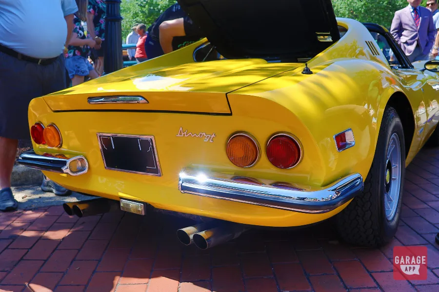 Low-angle shot of a Ferrari Dino 246 GT in Giallo Fly yellow, emphasizing the compact proportions and legendary mid-engine layout.