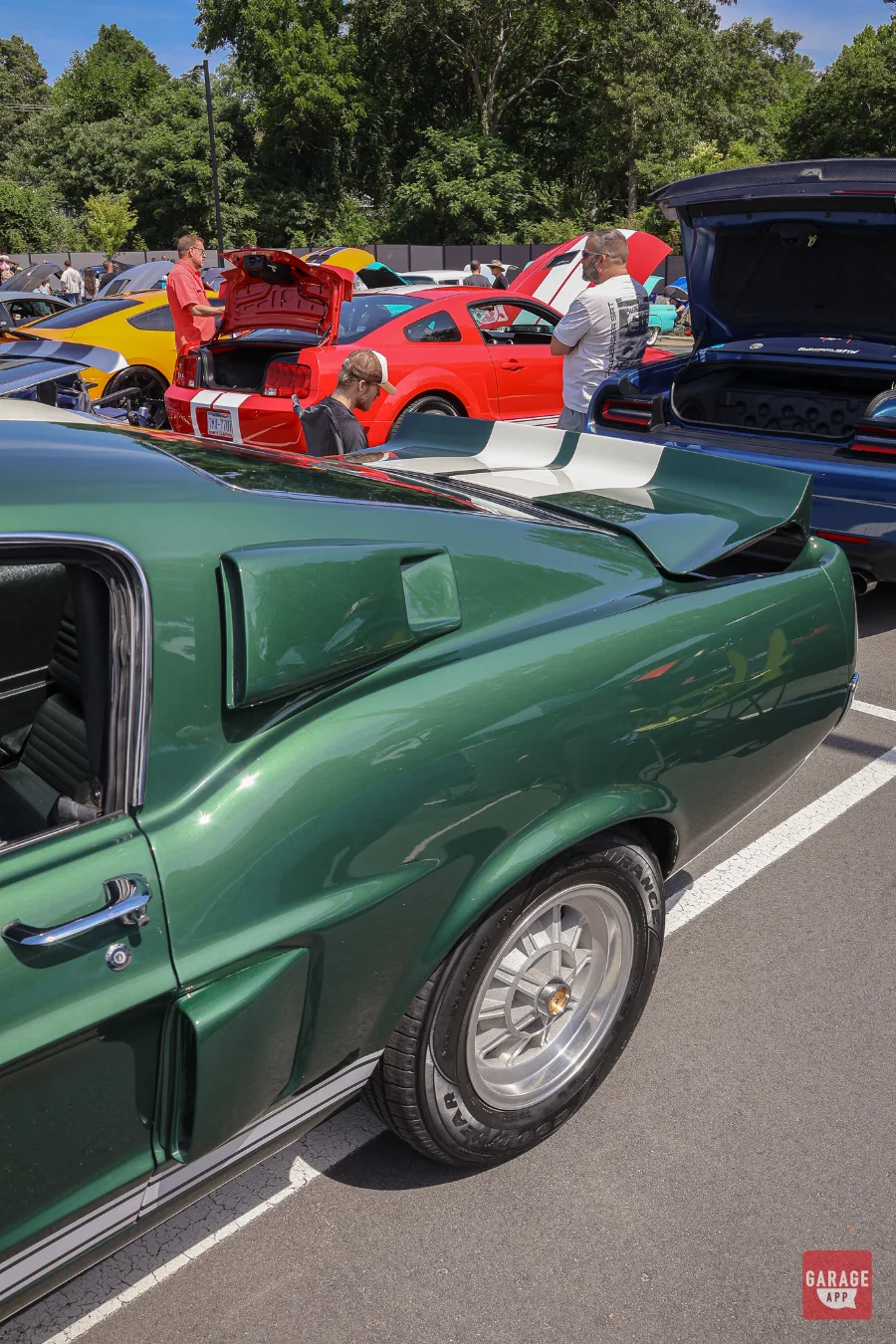 Rear quarter view of a dark green 1968 Shelby GT500 fastback highlighting its signature body lines and rear spoiler.