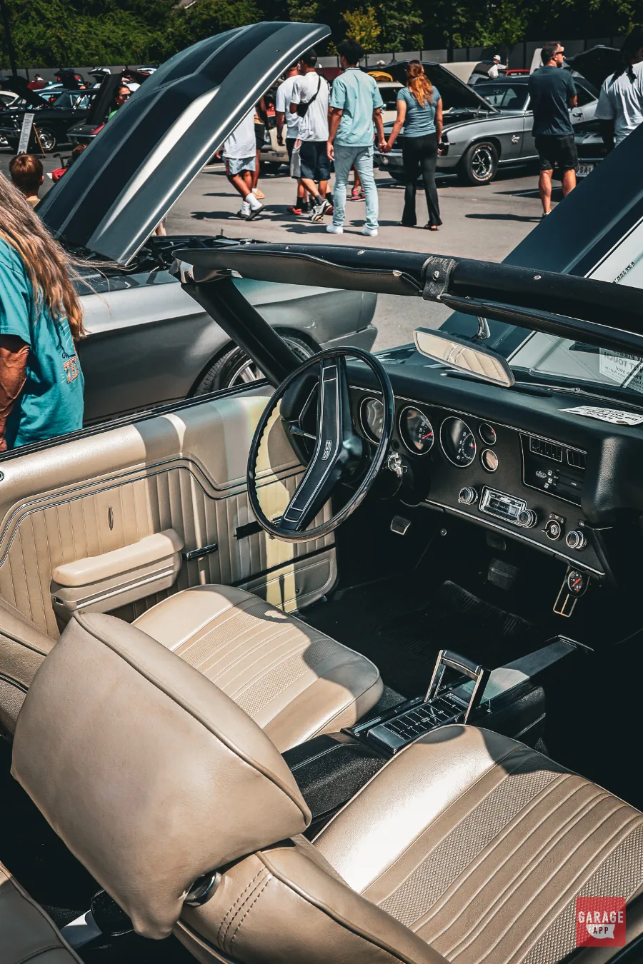 Driver cockpit of a 1970 Chevrolet Chevelle SS 454 Convertible with cream upholstery, SS steering wheel, gauges, and classic center console.