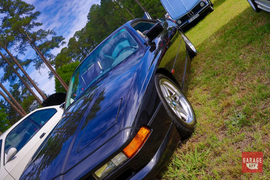 1995 BMW 840Ci E31 in black viewed from a low front quarter angle, showcasing the M60 V8 grand touring coupe and classic pop-up headlights.