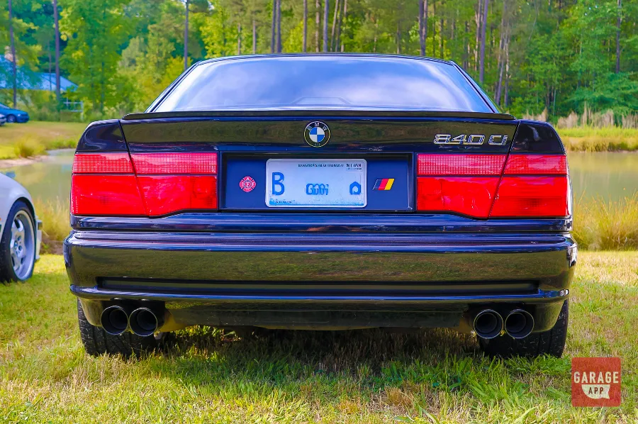 Rear badge detail of a black 1995 BMW 840Ci E31 showing the 840Ci emblem and quad exhaust system.