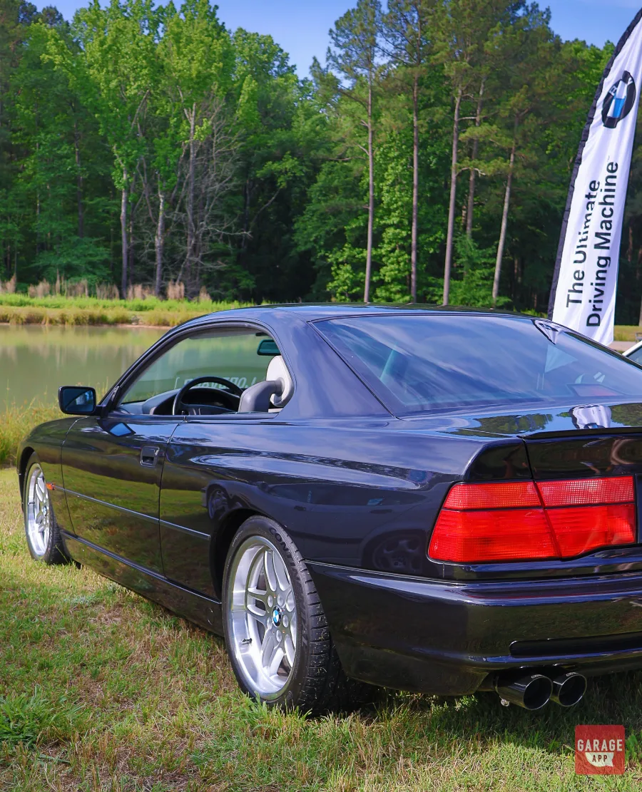 Rear three-quarter view of a black 1995 BMW 840Ci E31 parked outdoors, highlighting its pillarless coupe design and grand touring proportions.