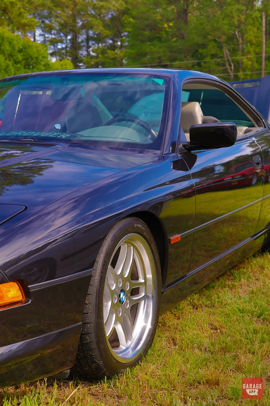 Side profile detail of a black 1995 BMW 840Ci E31 showing the pillarless body style, alloy wheels, and sleek grand touring silhouette.