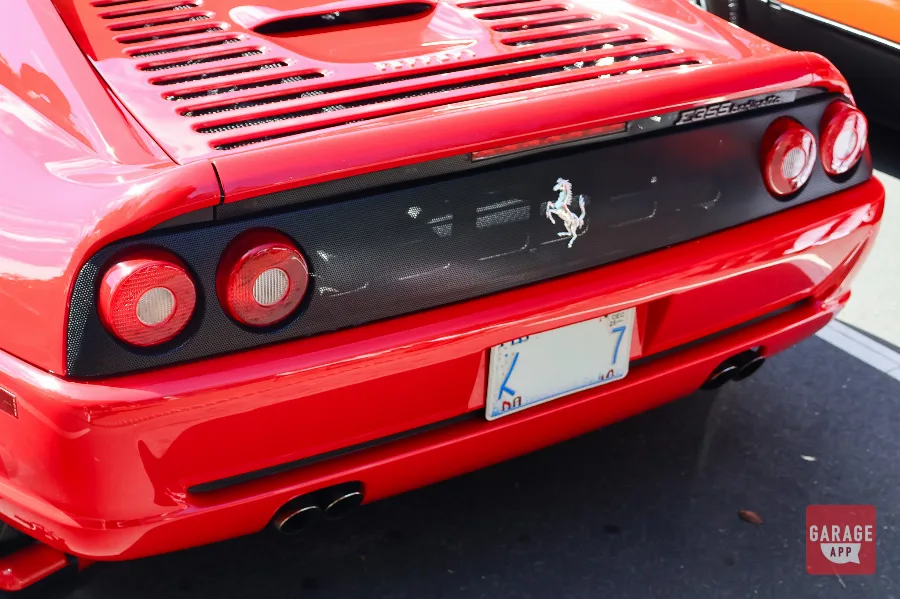 Rear view of a Ferrari F355 Berlinetta showing quad exhaust tips and signature round taillights.