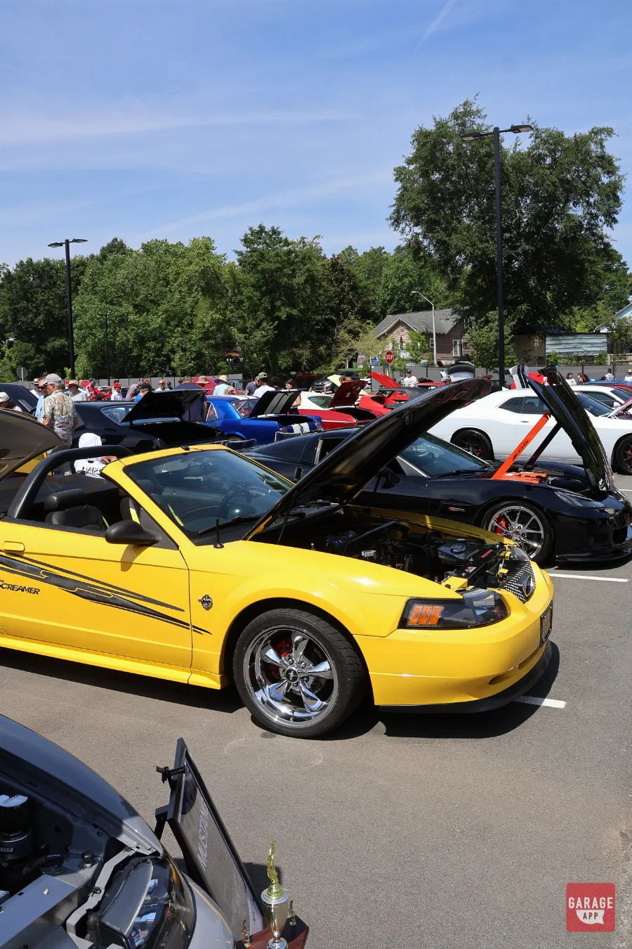 2004 Ford Mustang Mach 1 in Screaming Yellow displayed with the hood open at Fuquay-Varina Cars and Coffee.
