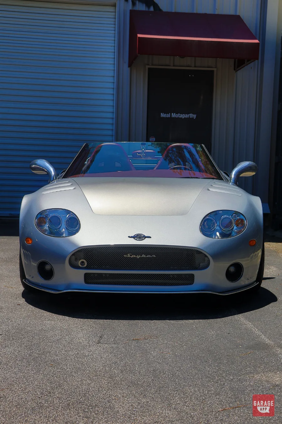 Front view of a 2006 Spyker C8 Spyder finished in Champion Silver, featuring its signature grille and aircraft-inspired styling cues.