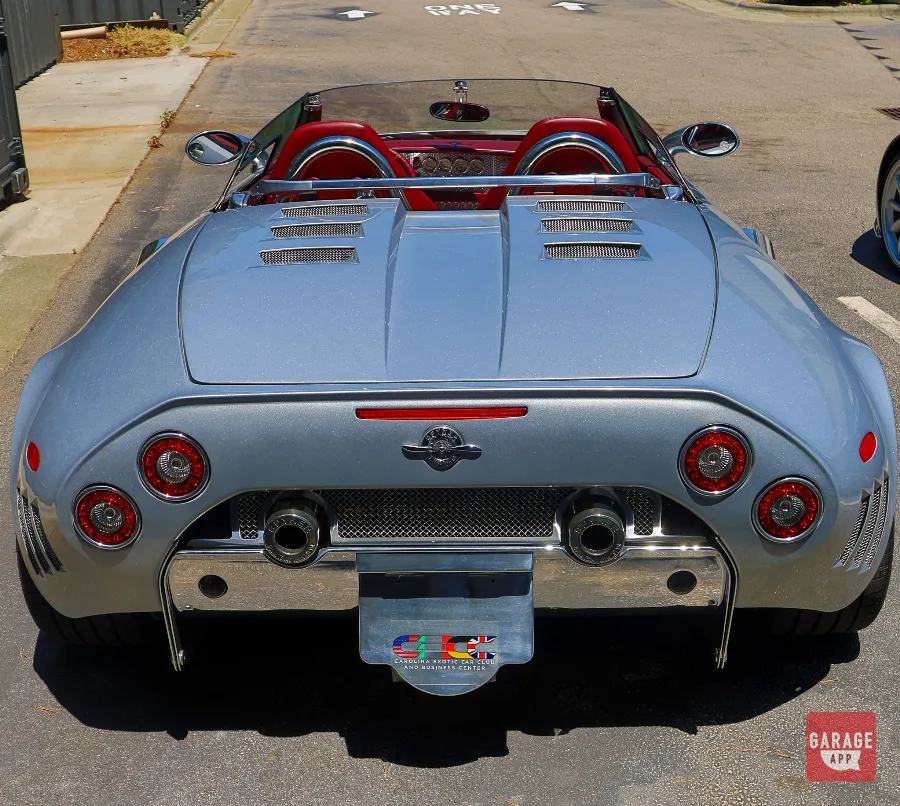 Rear view of a 2006 Spyker C8 Spyder in Champion Silver, showcasing its dual exhaust outlets and distinctive circular taillights.