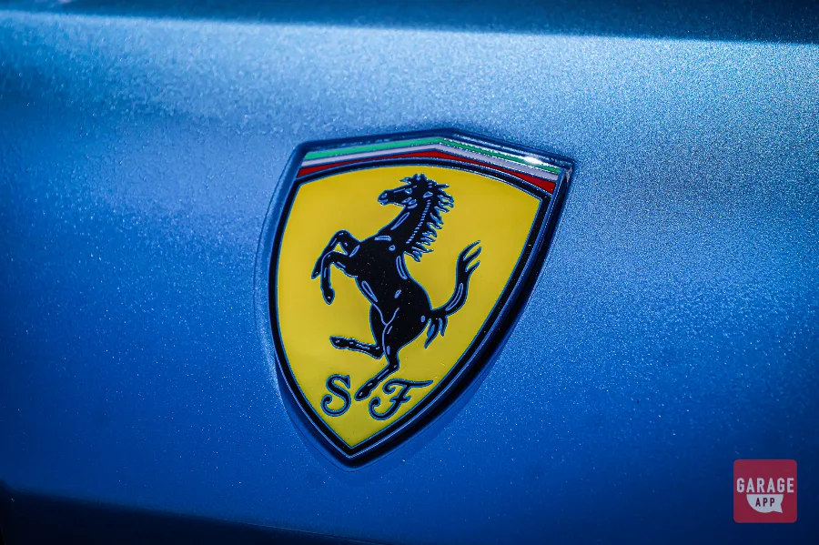 Ferrari Scuderia shield badge mounted on the front fender of a 2008 Ferrari 612 Scaglietti in Azzurro California