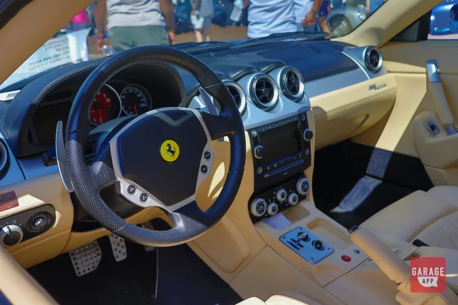 Ferrari 612 Scaglietti interior featuring tan leather seats, F1 transmission controls, aluminum trim, and a handcrafted grand touring cockpit