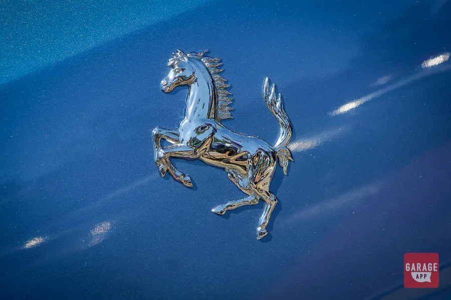 Ferrari prancing horse emblem mounted on the rear deck of a 2008 Ferrari 612 Scaglietti in Azzurro California