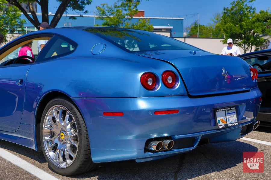 Rear three-quarter detail of a Ferrari 612 Scaglietti highlighting the twin exhaust outlets, circular taillights, and sculpted rear bodywork