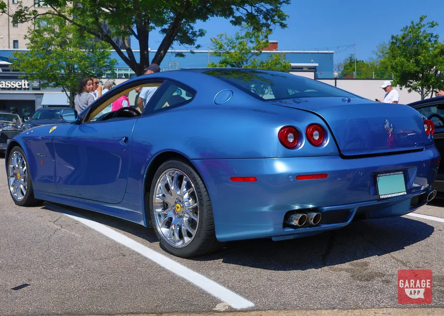 Wide rear three-quarter view of a 2008 Ferrari 612 Scaglietti finished in Azzurro California at an automotive gathering