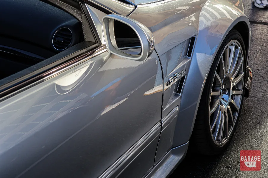 Close-up of the 6.3 AMG fender badge on a 2009 Mercedes-Benz CLK 63 AMG Black Series finished in Iridium Silver Metallic, highlighting the naturally aspirated M156 V8 and aggressive widebody design.