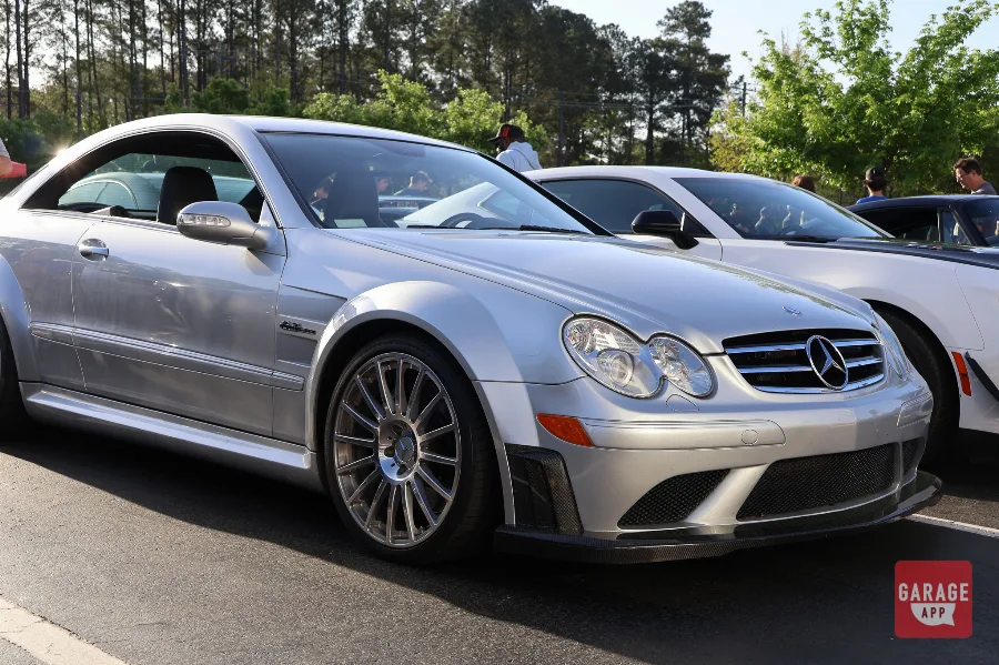 Front three-quarter view of a 2009 Mercedes-Benz CLK 63 AMG Black Series in Iridium Silver Metallic, showcasing the widebody fenders, carbon fiber splitter, and aggressive AMG styling.