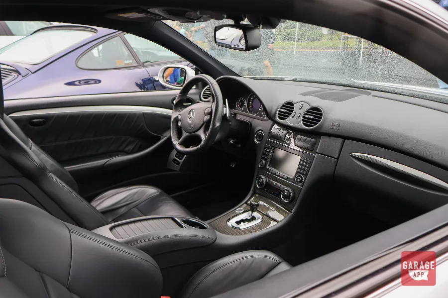Passenger-side interior of a 2009 Mercedes-Benz CLK 63 AMG Black Series, featuring carbon fiber trim, AMG performance seats, premium leather, and a driver-focused cockpit.