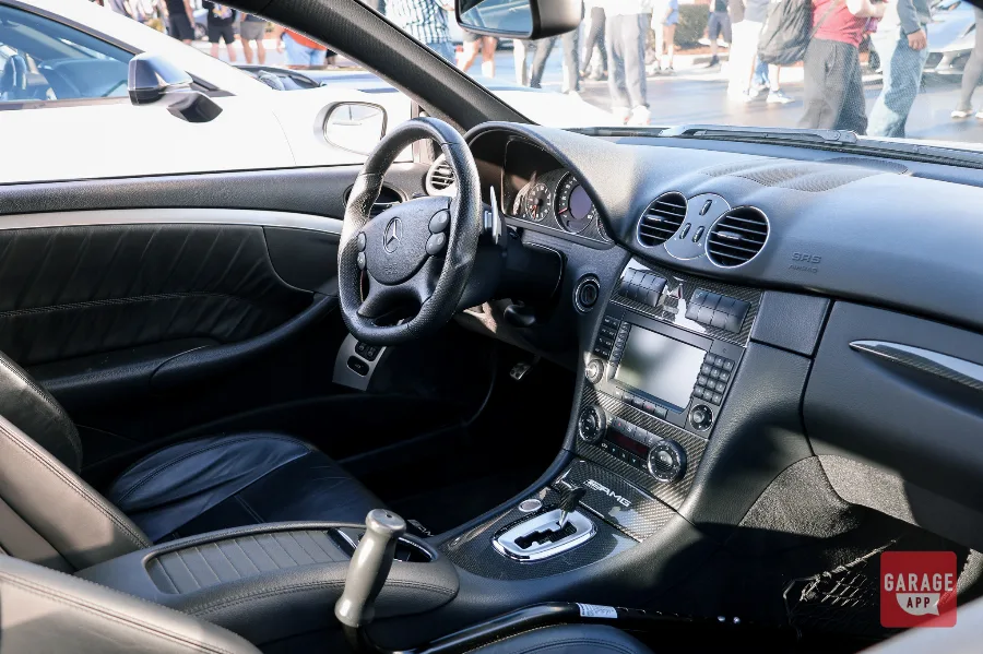 Interior cabin of a 2009 Mercedes-Benz CLK 63 AMG Black Series, showcasing AMG performance seats, carbon fiber trim, paddle shifters, and premium Mercedes-Benz craftsmanship.