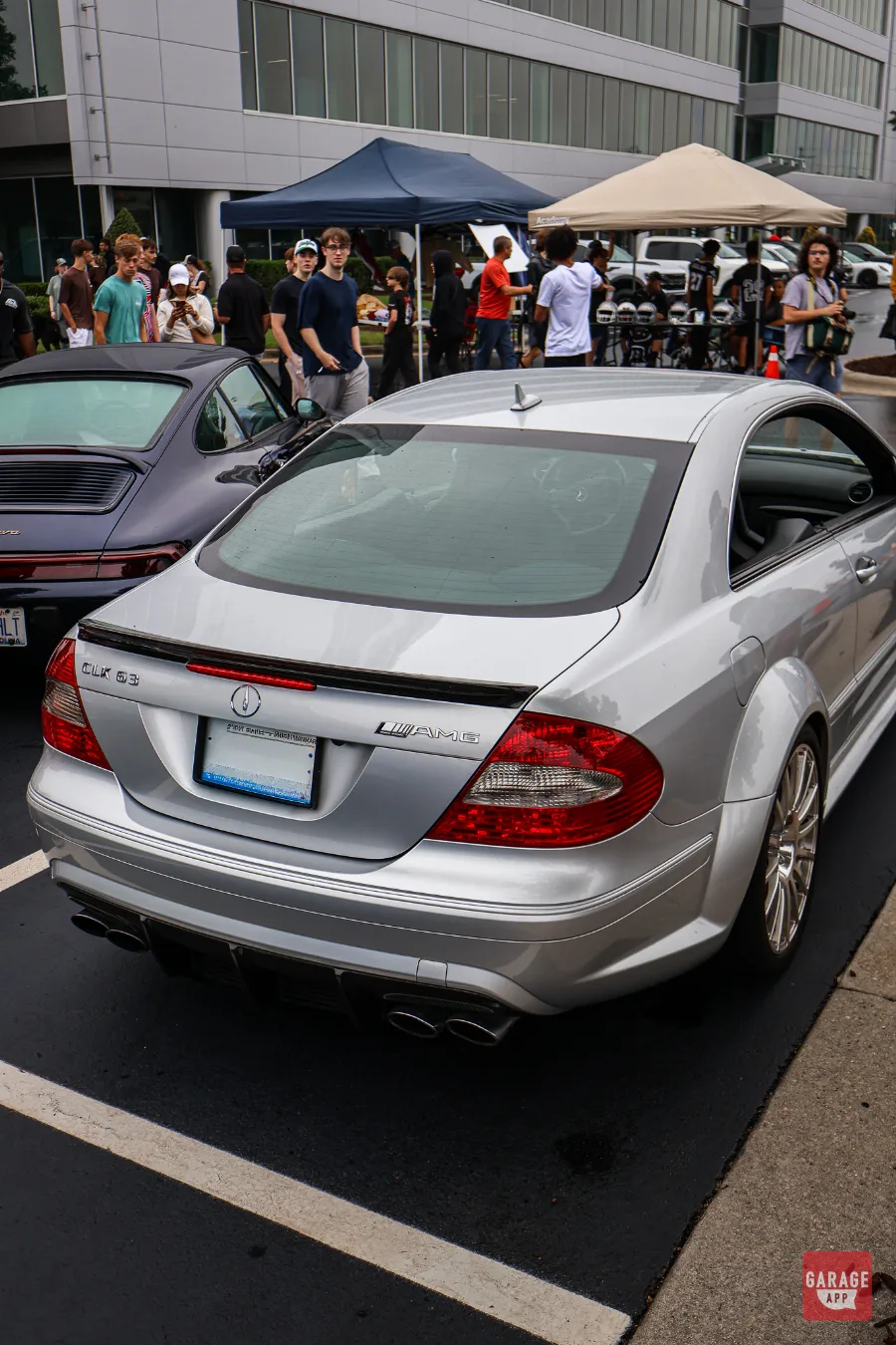 Rear three-quarter view of a 2009 Mercedes-Benz CLK 63 AMG Black Series in Iridium Silver Metallic, showcasing the flared rear fenders, carbon fiber spoiler, and quad exhaust tips.