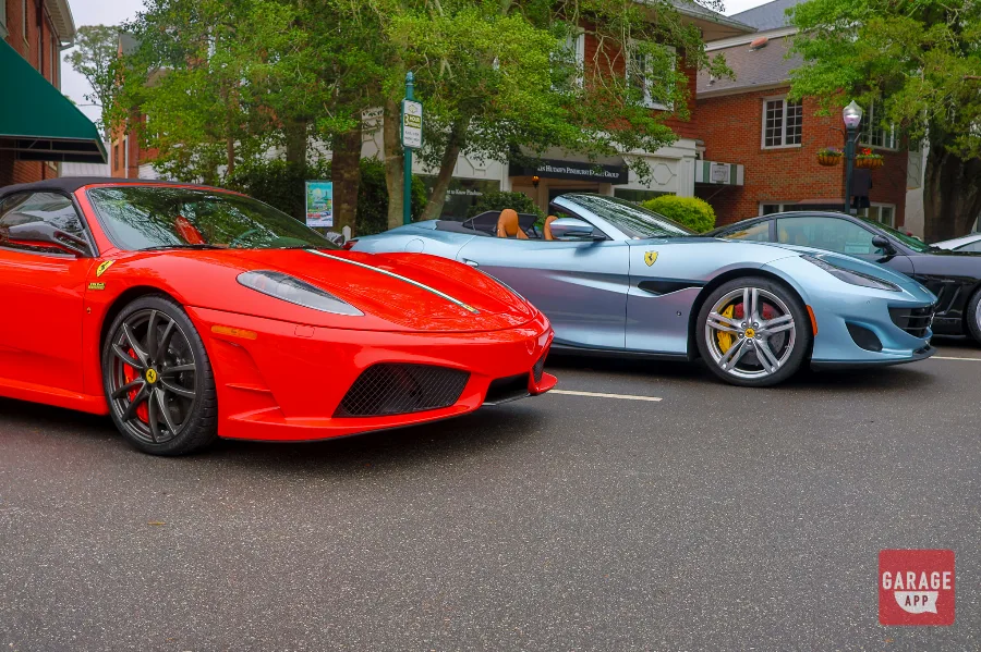 2009 Ferrari F430 Scuderia Spider 16M parked beside a Ferrari Portofino at a Cars and Coffee event celebrating Ferrari heritage.