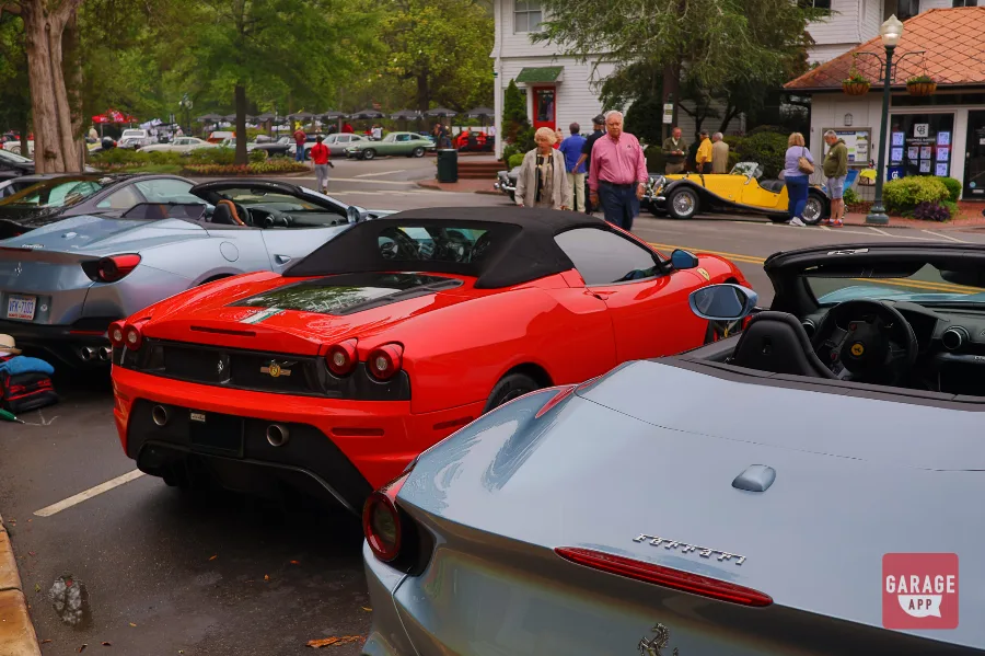 Rear three-quarter view of the 2009 Ferrari F430 Scuderia Spider 16M displayed among Ferraris during a community automotive event.