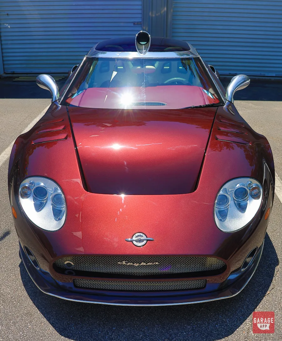 Front view of a 2009 Spyker C8 Laviolette finished in Madeira Red with its signature roof-mounted air intake and sculpted hood vents.