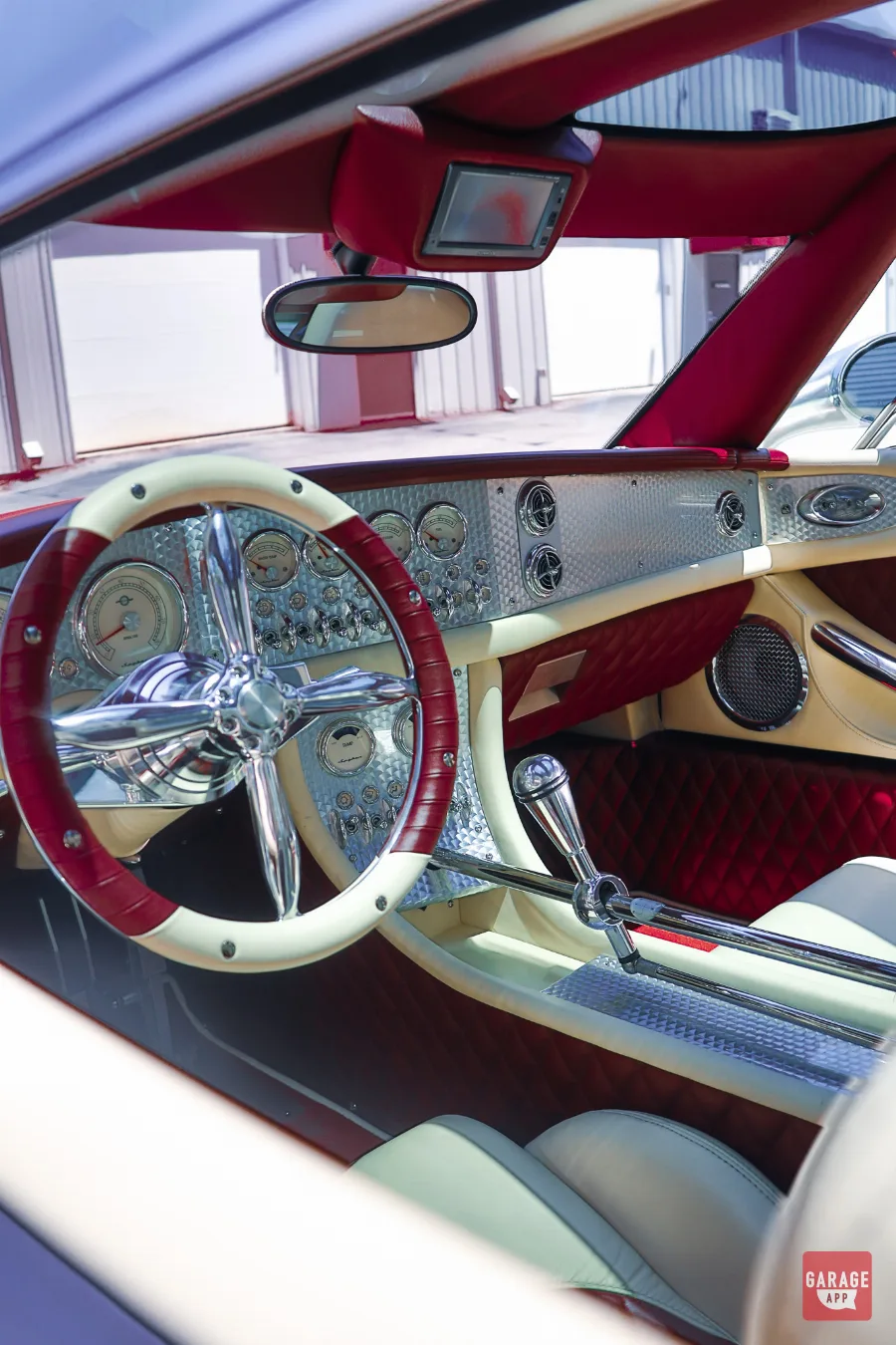 Two-tone leather interior of a 2009 Spyker C8 Laviolette featuring a polished aluminum dashboard, exposed linkage shifter, and aviation-inspired controls.