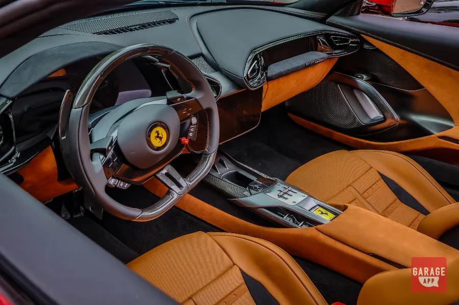 2025 Ferrari 12Cilindri Spider interior in Rosso Corsa with Cuoio leather seats, carbon fiber steering wheel, digital cockpit, and grand touring cabin design.