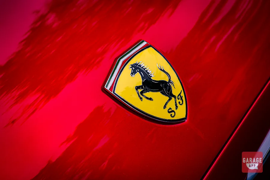 Close-up of the Ferrari shield emblem on a 2025 Ferrari 12Cilindri Spider finished in Rosso Corsa red paint.