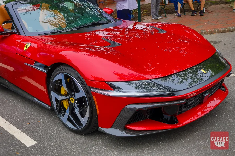 Front three-quarter view of a 2025 Ferrari 12Cilindri Spider in Rosso Corsa with yellow brake calipers and carbon fiber aerodynamic elements.