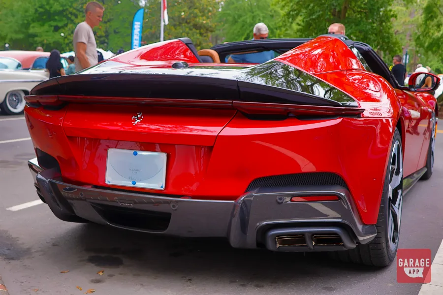 Close-up of the hood and front fender on a 2025 Ferrari 12Cilindri Spider in Rosso Corsa highlighting sculpted bodywork and carbon fiber vents.