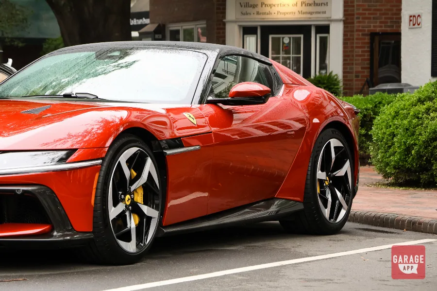 Front side profile of a 2025 Ferrari 12Cilindri Spider in Rosso Corsa showing classic front-engine proportions and Ferrari grand tourer styling.