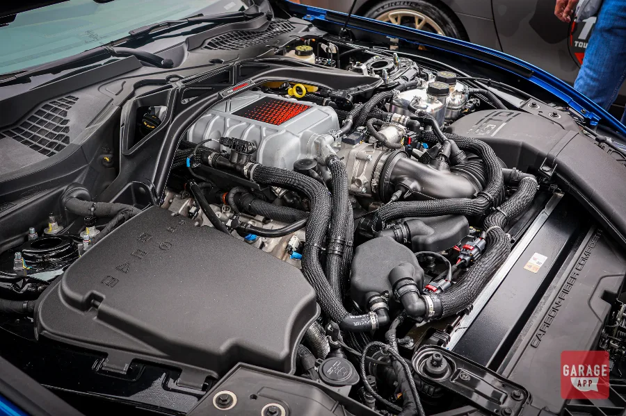 Close-up of the supercharged V8 engine in a 2025 Ford Mustang GTD, showcasing Ford Performance engineering, carbon fiber bracing, and race-inspired engine components.