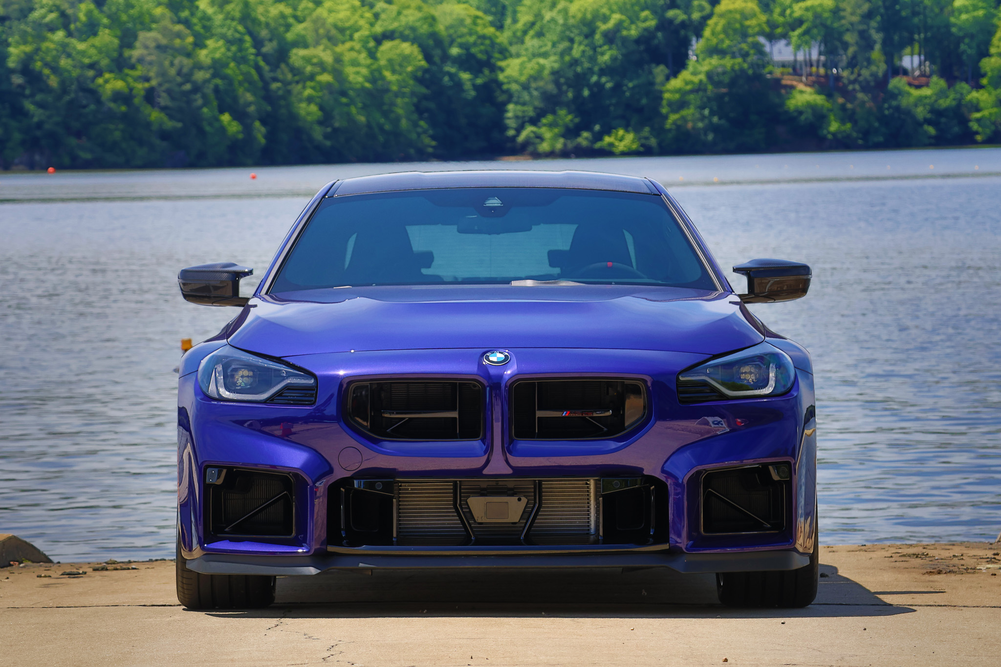 Front view of a 2026 BMW M2 CS in Velvet Blue showing the redesigned front fascia and signature BMW kidney grilles.