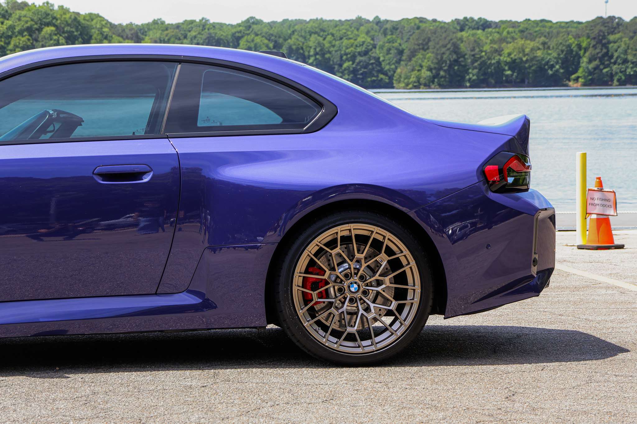 Rear quarter detail of a 2026 BMW M2 CS in Velvet Blue featuring bronze wheels, red brake calipers, and wide rear fenders.