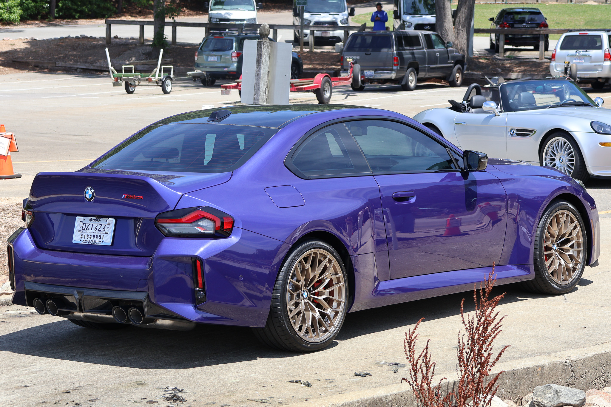 Close rear three-quarter view of a 2026 BMW M2 CS in Velvet Blue with quad exhaust tips and carbon fiber rear diffuser.