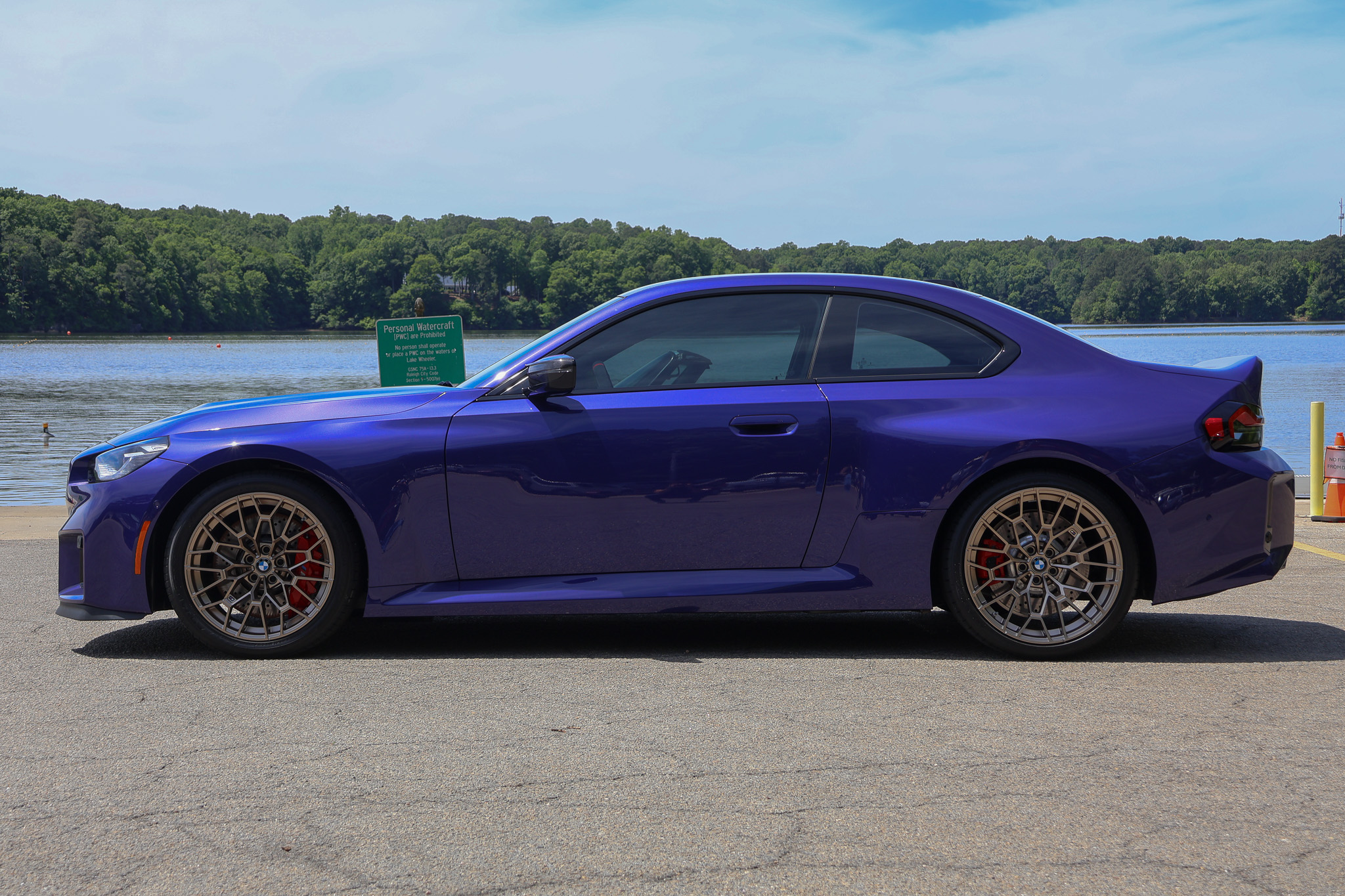 Side profile of a 2026 BMW M2 CS in Velvet Blue featuring bronze forged wheels and the signature G87 coupe silhouette.