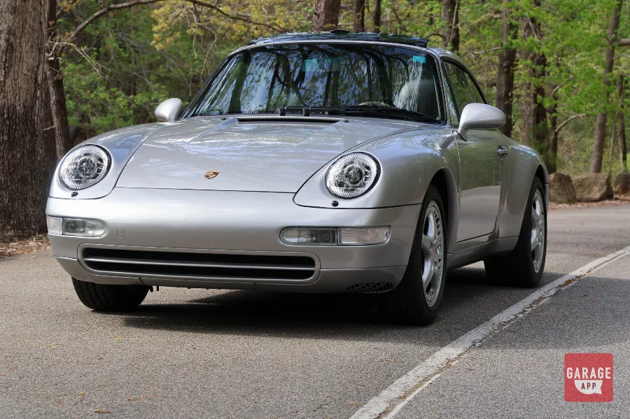 Front view of a Porsche 993 Targa displaying the legendary round headlights and low stance.