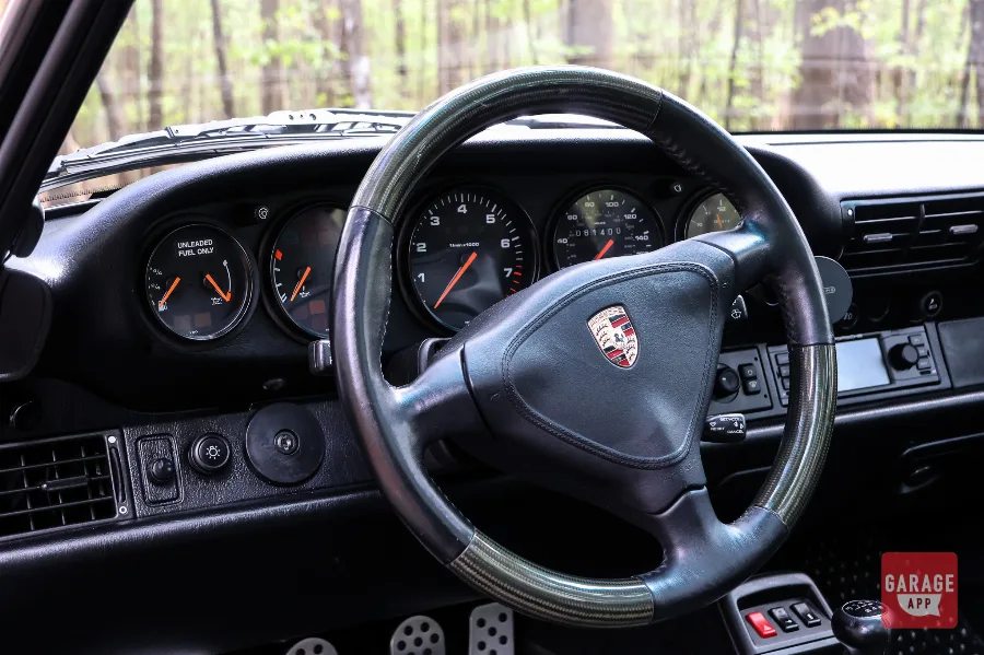 Interior of a Porsche 993 Targa featuring classic analog gauges, a driver-focused cockpit, and the timeless design that defines the final air-cooled Porsche 911 generation.