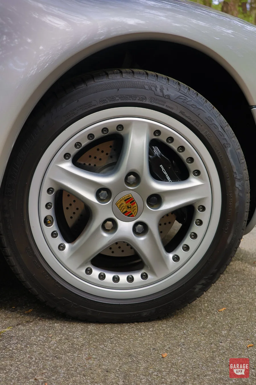 Close-up of a Porsche 993 Targa wheel featuring the classic Porsche design, performance braking system, and timeless air-cooled 911 styling.