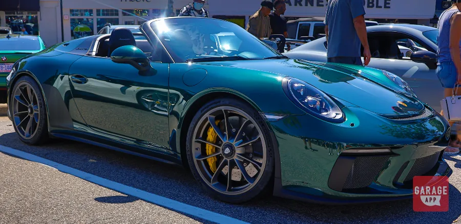 Low-angle photograph of a green Porsche 911 Speedster emphasizing its aggressive stance and performance-focused proportions.