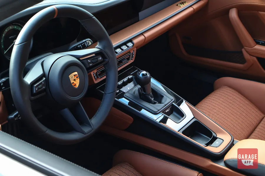 Interior of a 2024 Porsche 911 S/T featuring lightweight bucket seats, a six-speed manual transmission, and a driver-focused cockpit finished in premium Porsche materials.