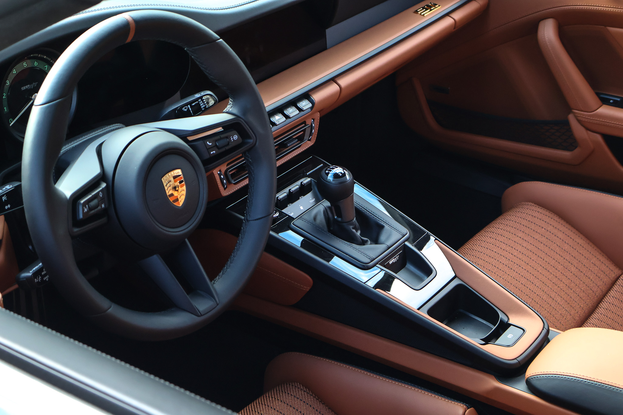 Interior of a 2024 Porsche 911 S/T featuring lightweight bucket seats, a six-speed manual transmission, and a driver-focused cockpit finished in premium Porsche materials.