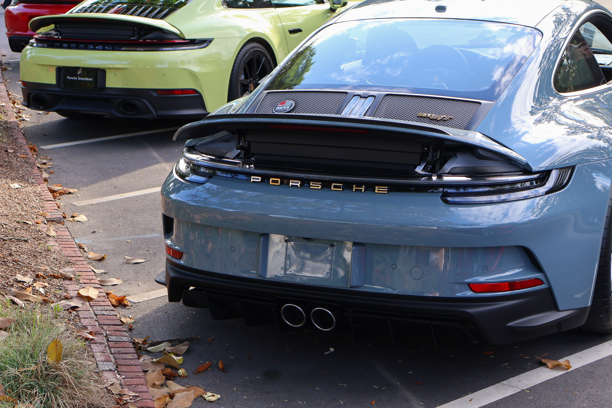 Rear view of a 2024 Porsche 911 S/T finished in Shore Blue Metallic, showcasing the clean rear design and limited-production sports car styling.