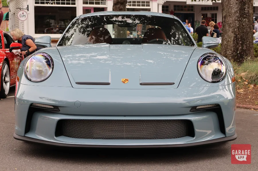 Front view of a 2024 Porsche 911 S/T in Shore Blue Metallic, displaying the signature round headlights and naturally aspirated Porsche performance.
