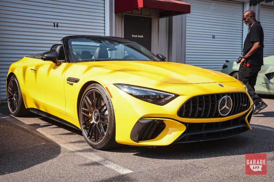 Front left three-quarter view of a 2025 Mercedes-AMG SL 63 in MANUFAKTUR Sun Yellow, showcasing the handcrafted twin-turbo V8 roadster, Panamericana grille, and aggressive AMG styling.