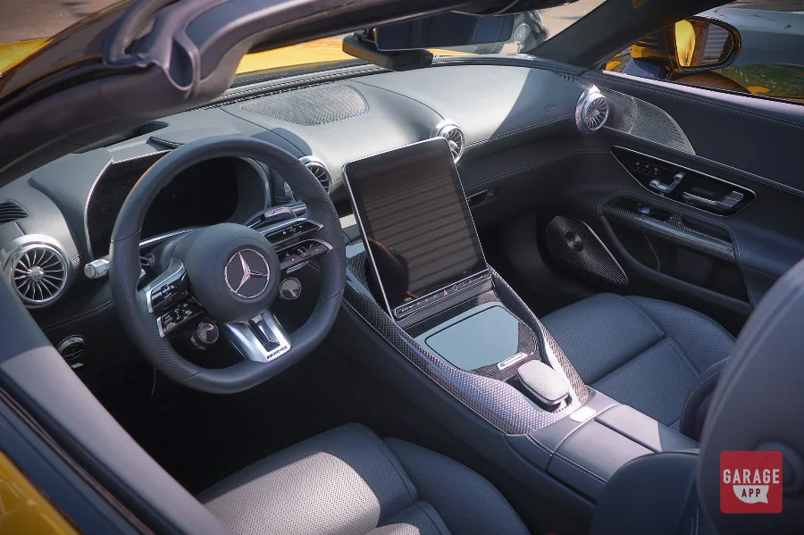 Interior of a 2025 Mercedes-AMG SL 63 featuring AMG Performance seats, a portrait touchscreen, premium leather, and a driver-focused luxury cockpit.
