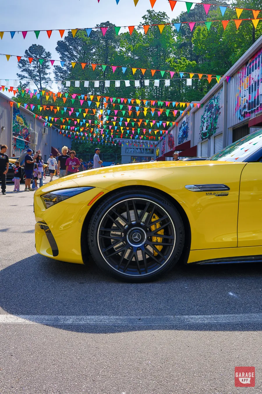 Front wheel and fender of a 2025 Mercedes-AMG SL 63 in MANUFAKTUR Sun Yellow, showcasing AMG multi-spoke wheels, high-performance brakes, and aggressive body styling.