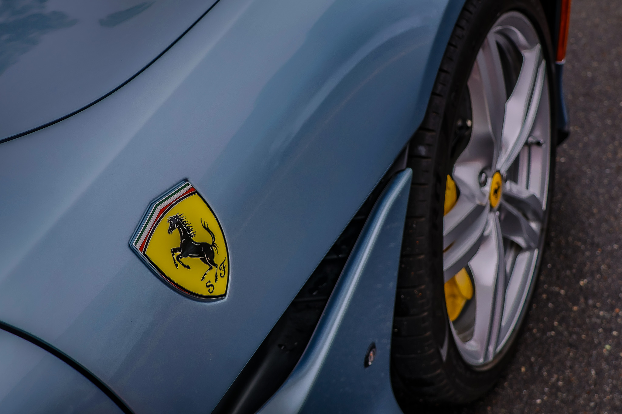 Close-up of the Ferrari Portofino front fender and wheel design, emphasizing the iconic prancing horse badge.