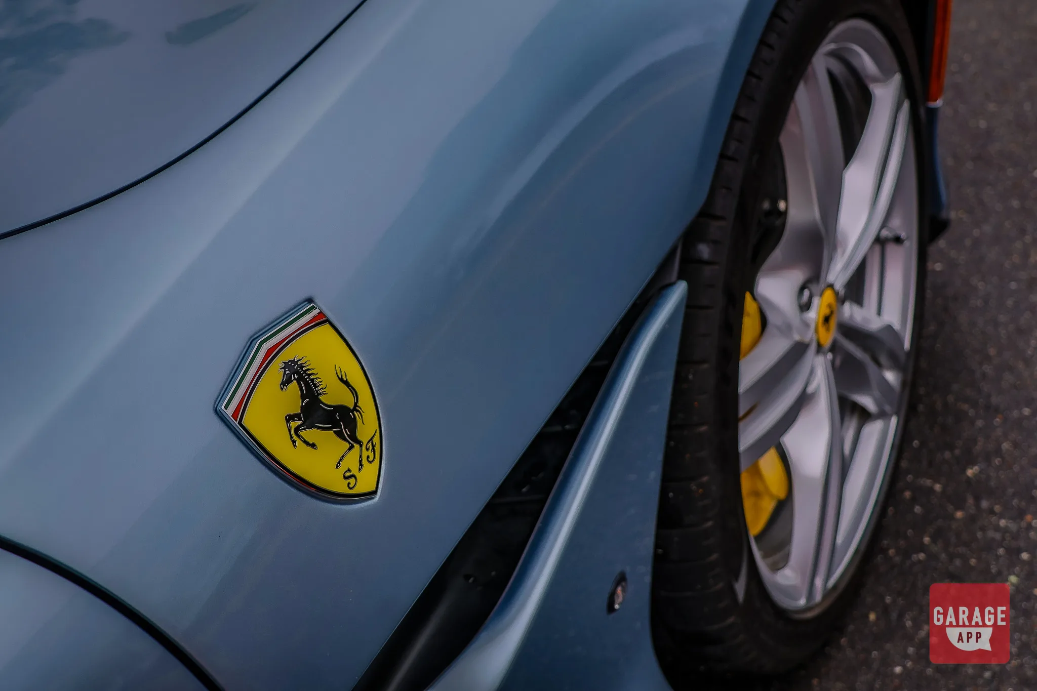 Close-up of the Ferrari Portofino front fender and wheel design, emphasizing the iconic prancing horse badge.