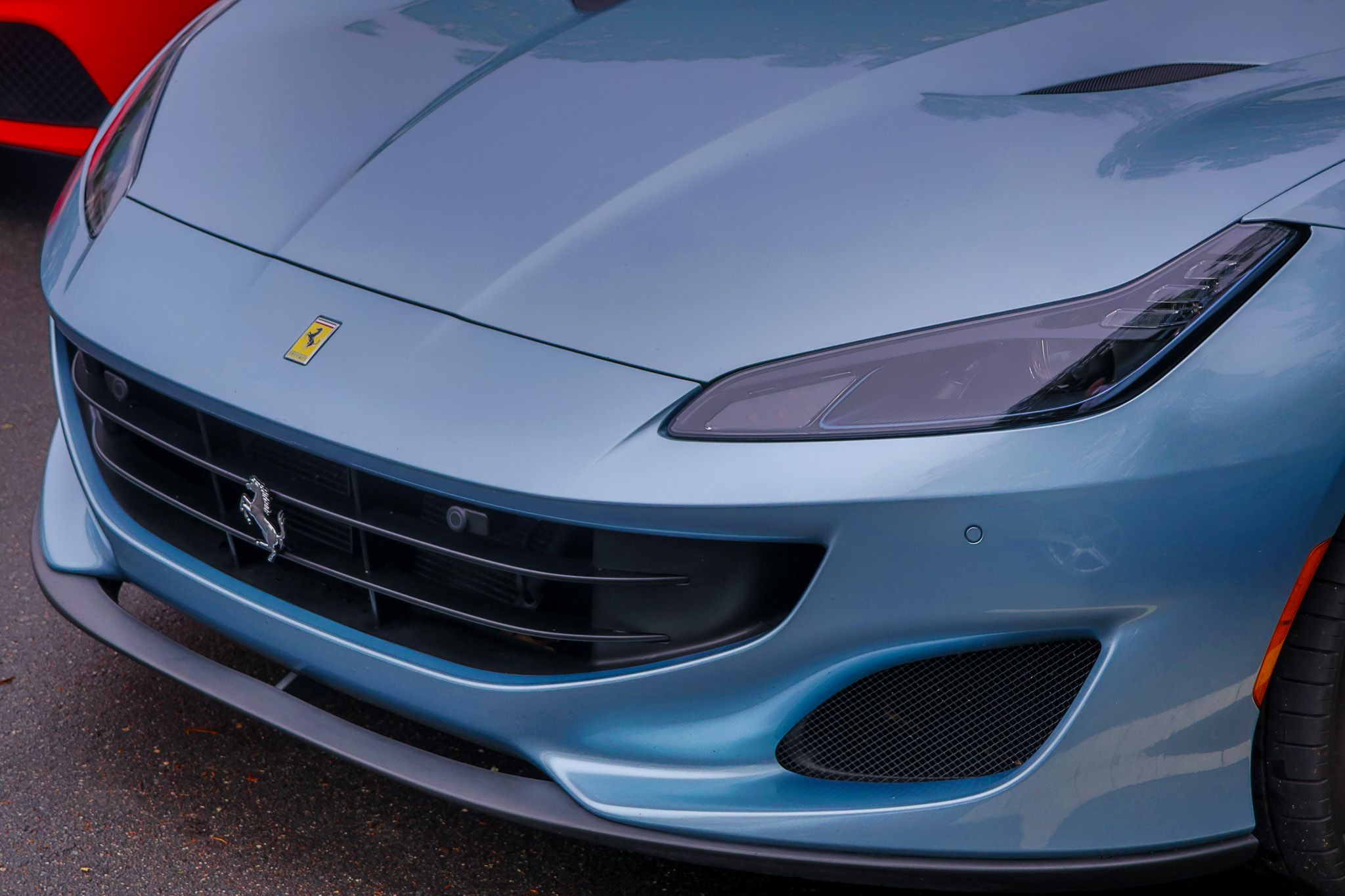 Front corner shot of a 2019 Ferrari Portofino emphasizing the aerodynamic lines and luxury sports car proportions.